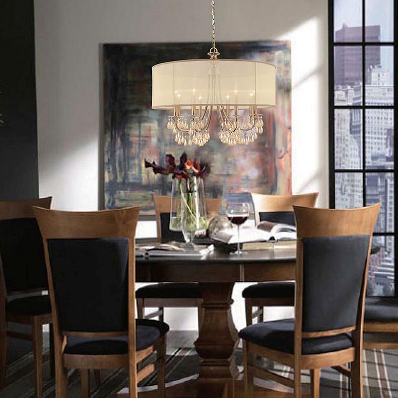 crystal chandelier with a linen shade hanging over a dining room table