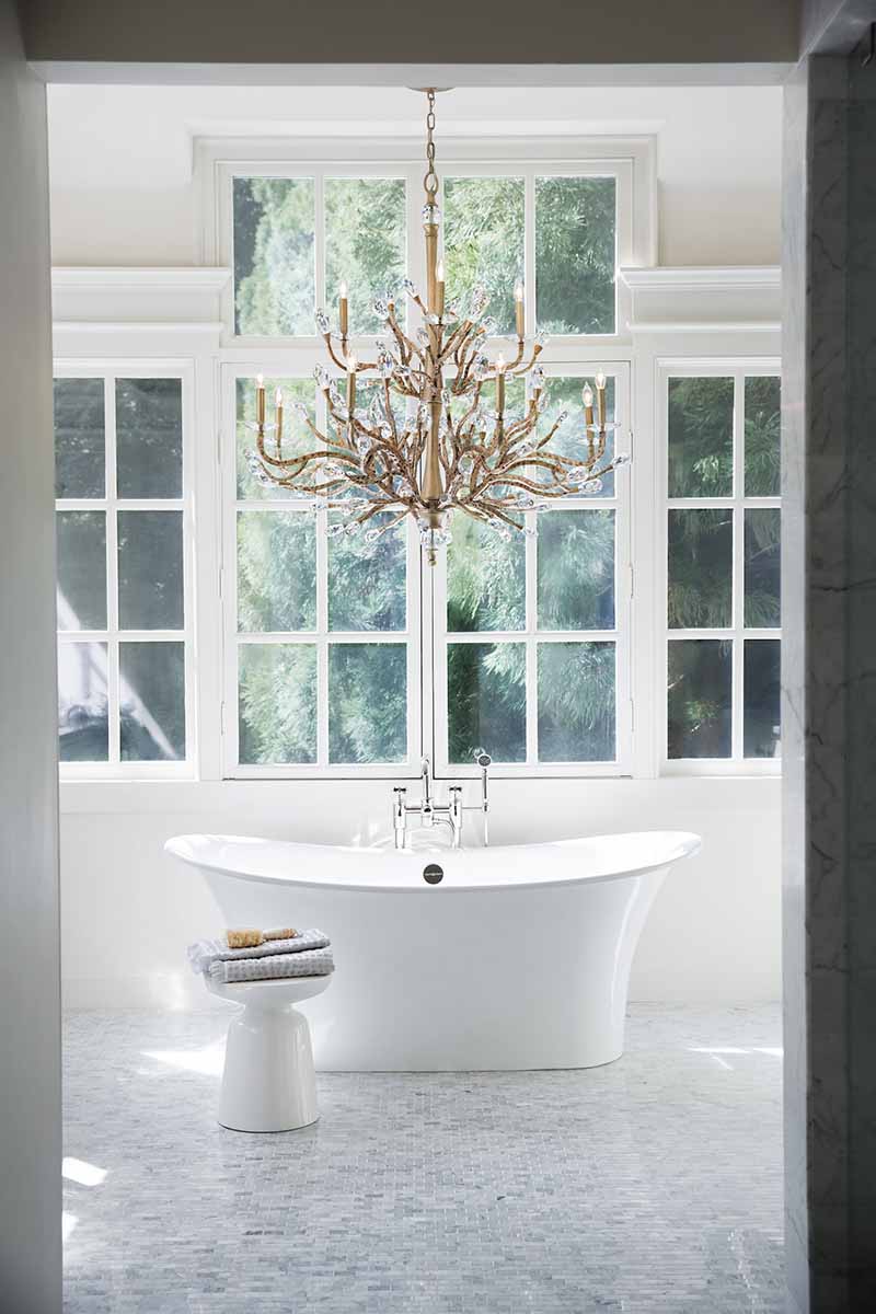 branch-like crystal chandelier hanging over a bathtub
