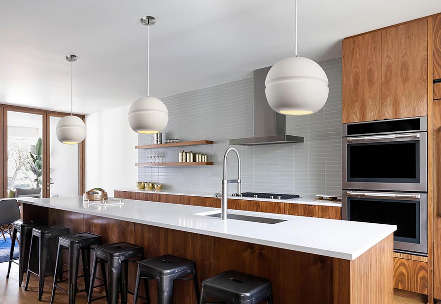 three circular ceramic mini pendant lights hanging over kitchen island 