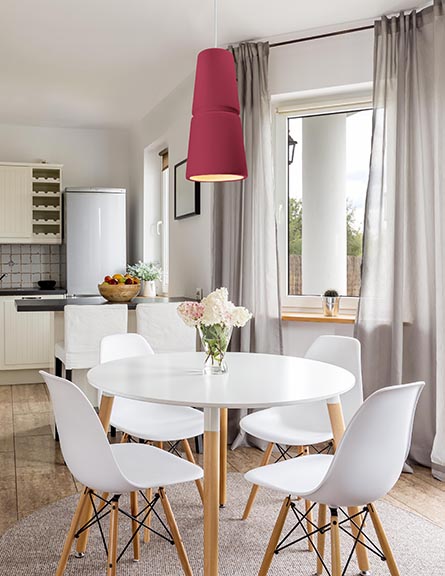 one magenta ceramic pendant light hanging over kitchen table