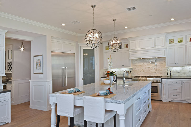 2 orb-shaped crystal chandeliers hanging over a kitchen island