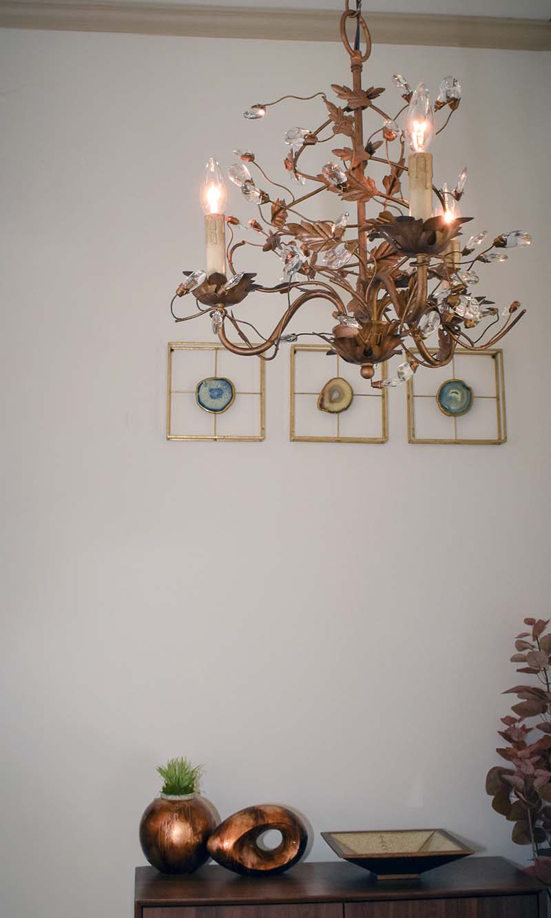three light crystal chandelier hanging in a hallway