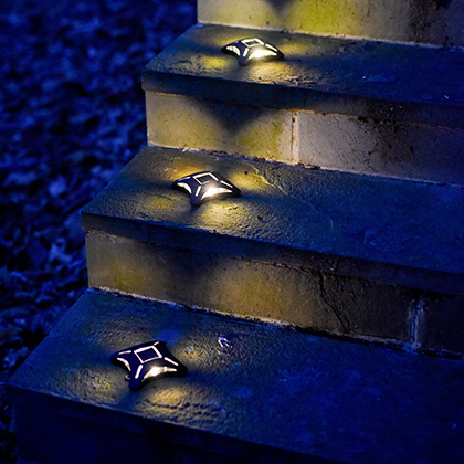 4 solar step lights lit up at night