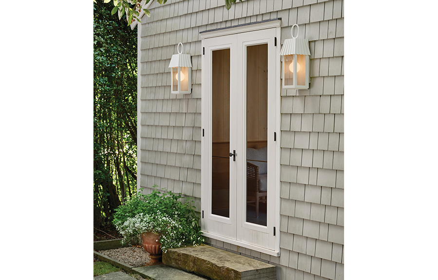 two white outdoor wall sconces hung on either side of back door