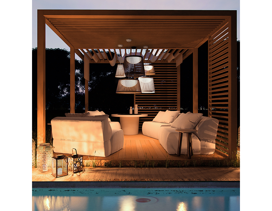 outdoor deck scene at dusk, with wood plank flooring, white stuffed chairs, white fire table, wood slatted pergola walls leading to a wood slatted pergola ceiling, from which are hung multiple sizes and colors of Maxim Lighting Bahama 54376WT pendant lights